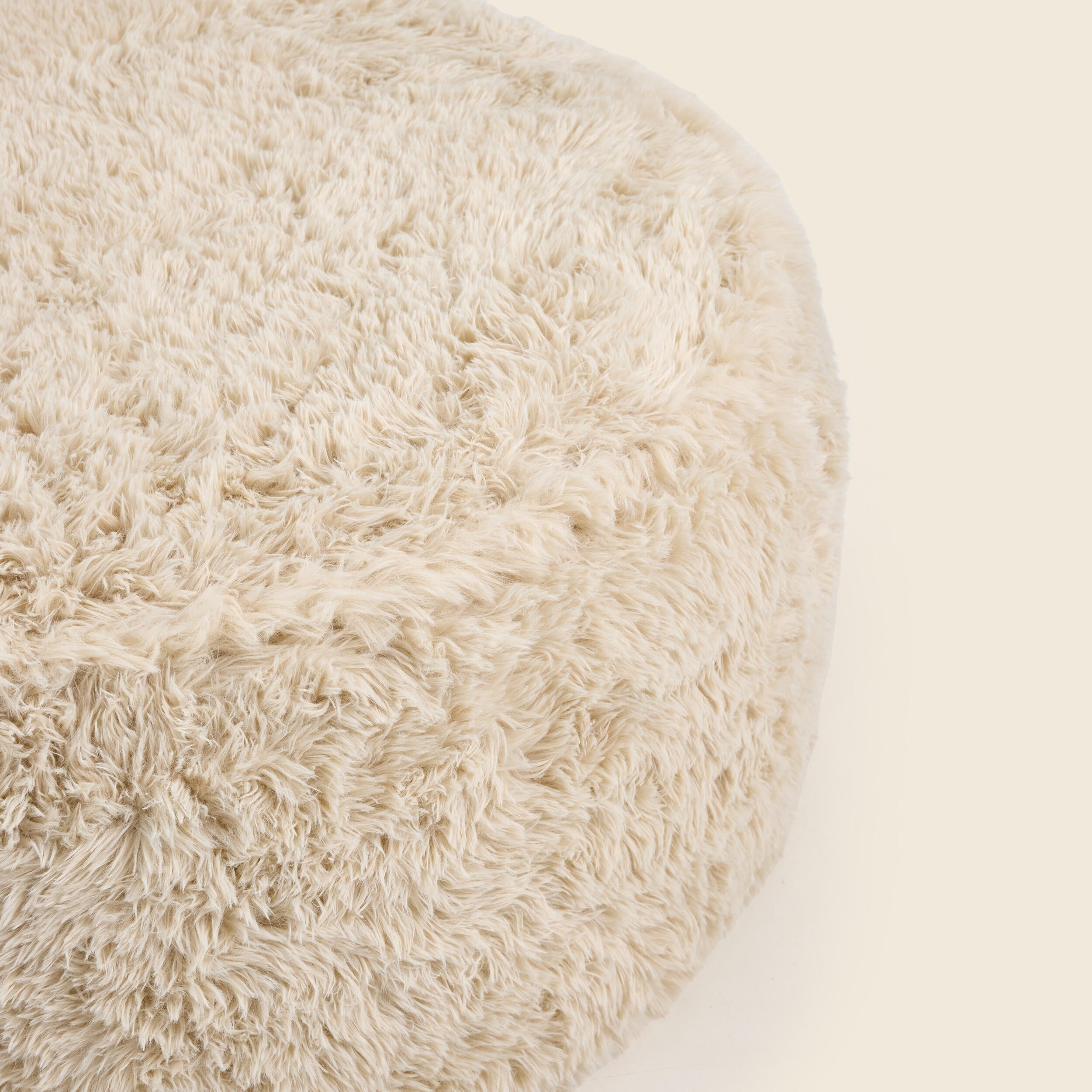 Close up of round beige pouf on a beige background