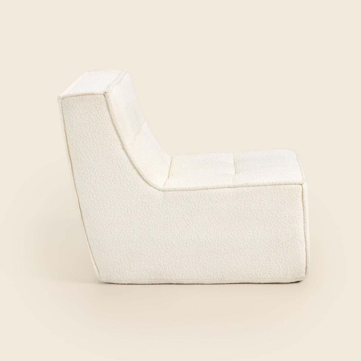 Ivory bouclé Loungi Occasional Chair, side view on a beige background