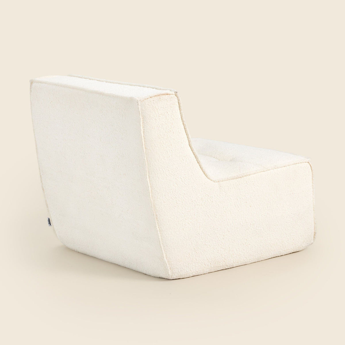 Ivory bouclé Loungi Occasional Chair on a beige background