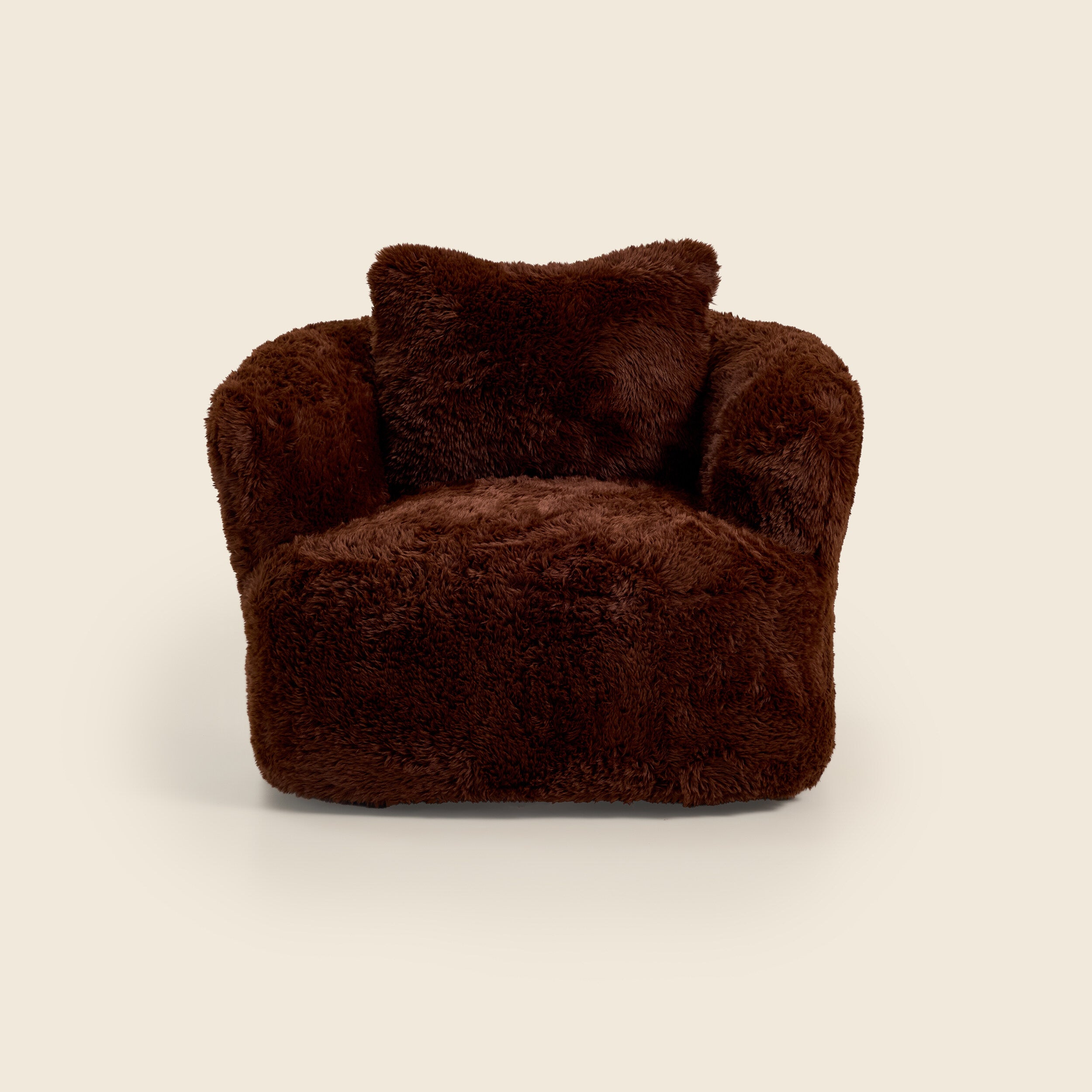 Brown plush armchair with a pillow on a beige background