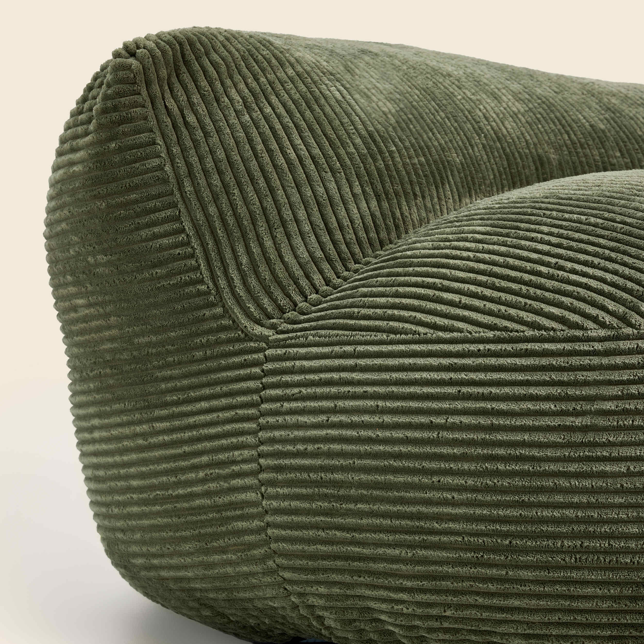 Close-up of a green corduroy chair on a light background