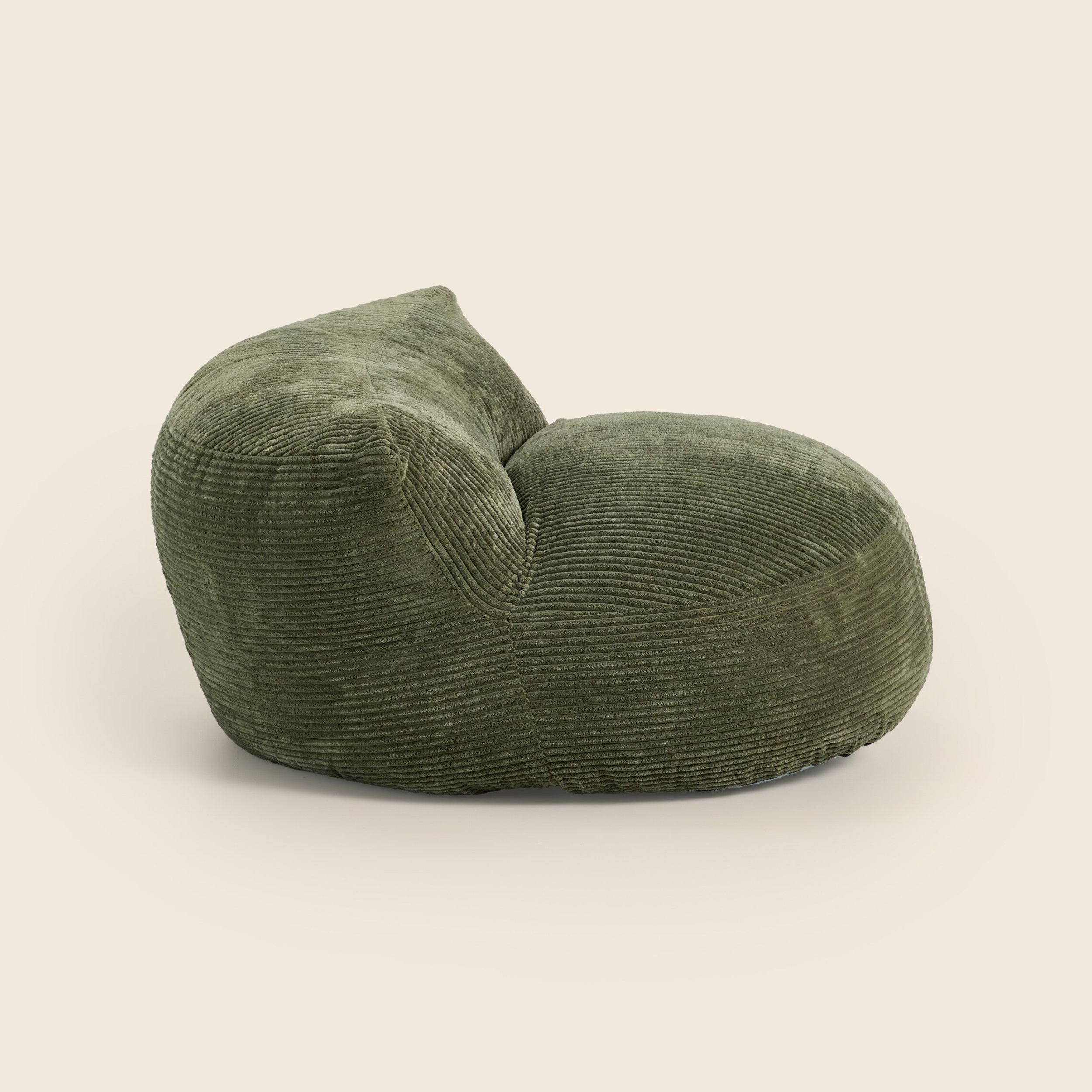 Green corduroy armchair on a beige background
