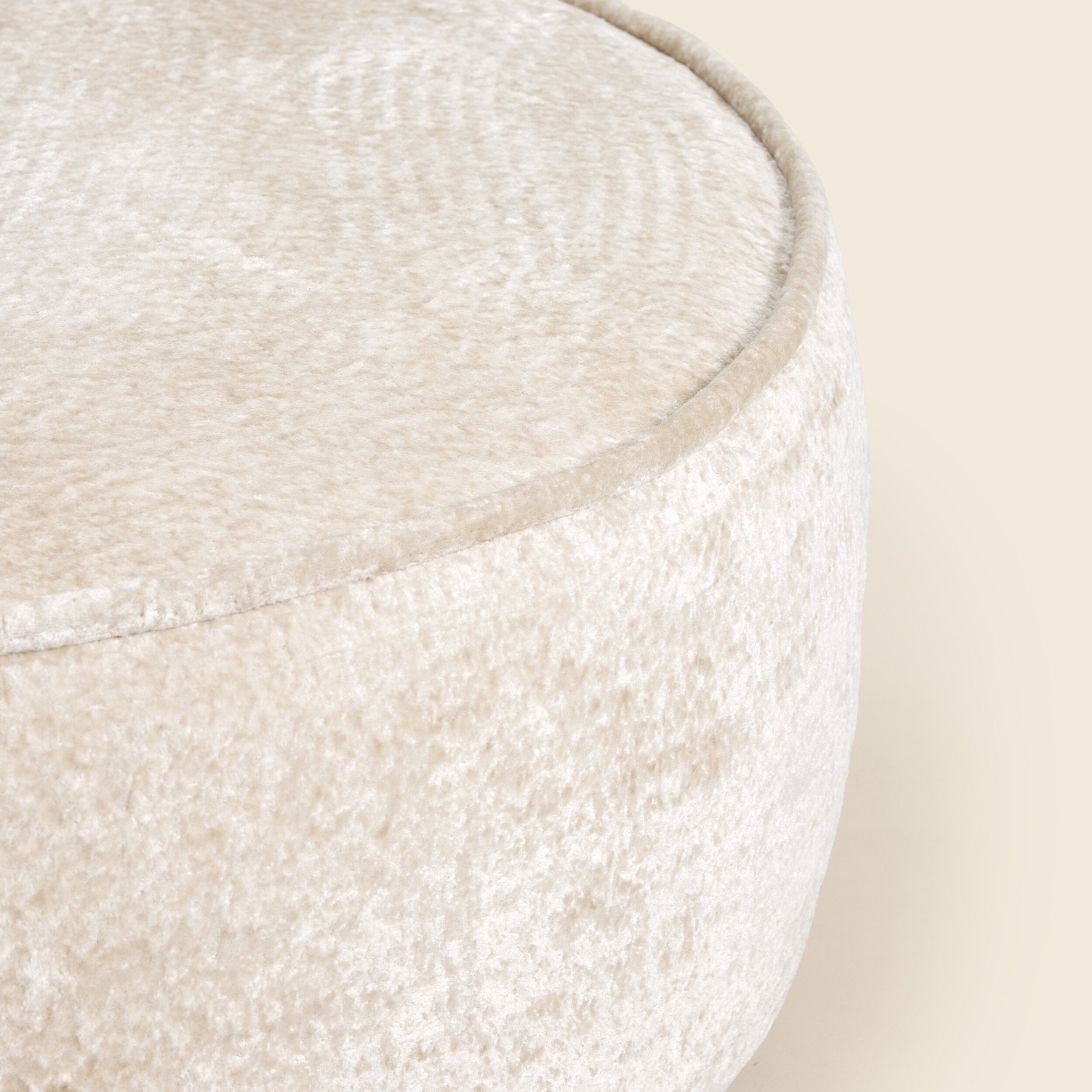 Close up of white ottoman on a beige background