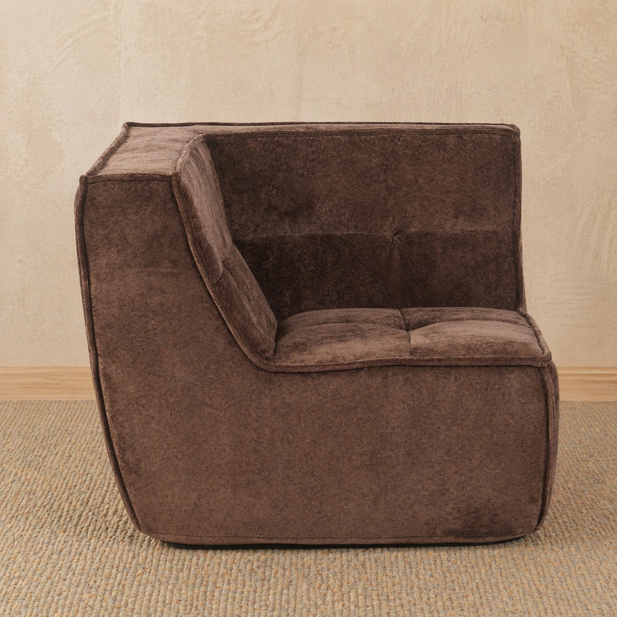 Brown upholstered chair against a beige wall.