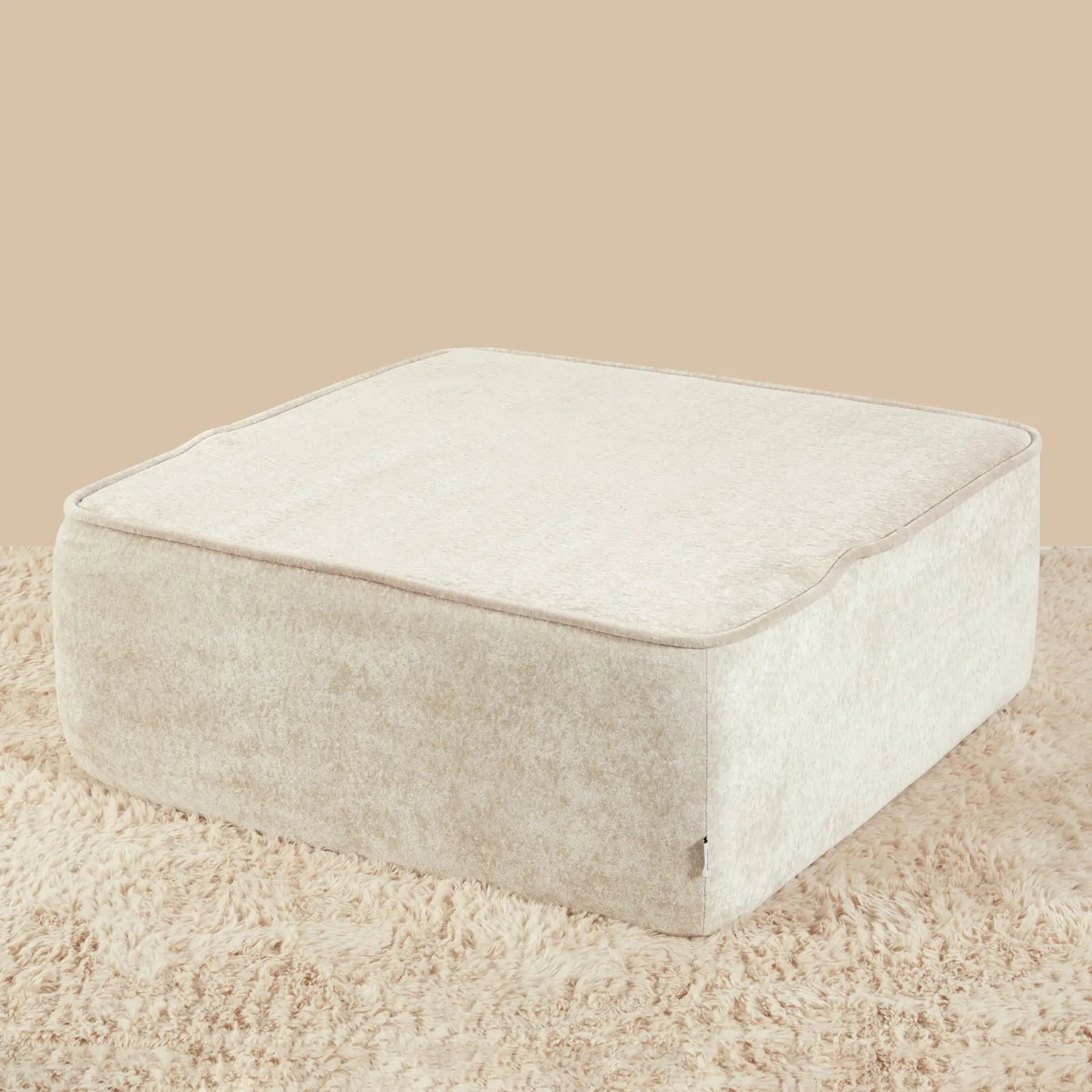 Beige ottoman on a beige carpet