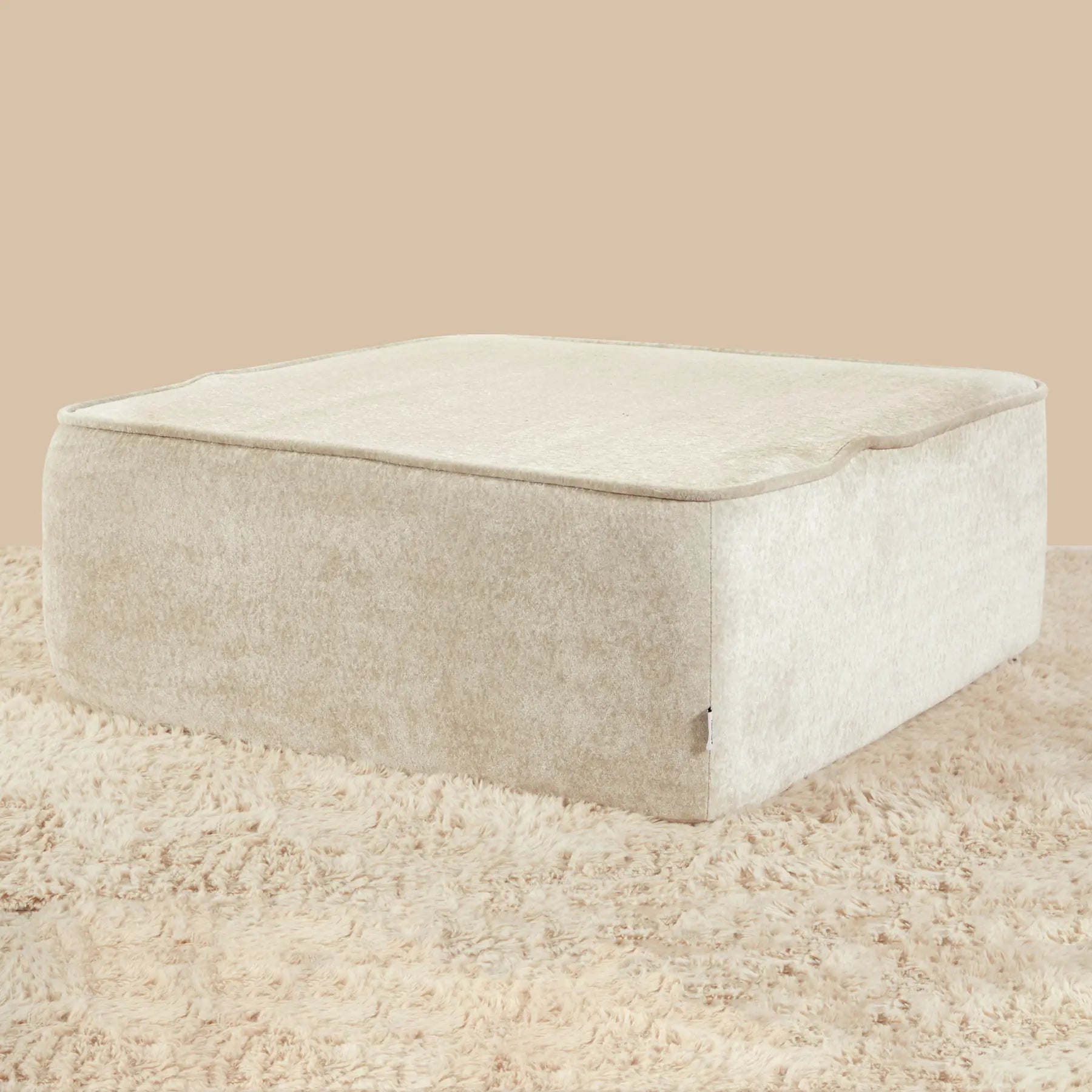 Beige rectangular ottoman on a beige carpet