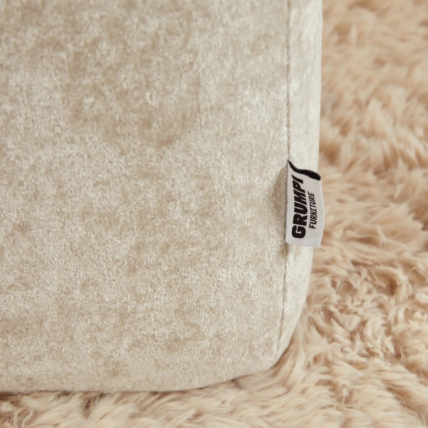 Close-up of a beige textured surface with a 'Grumpi' label.