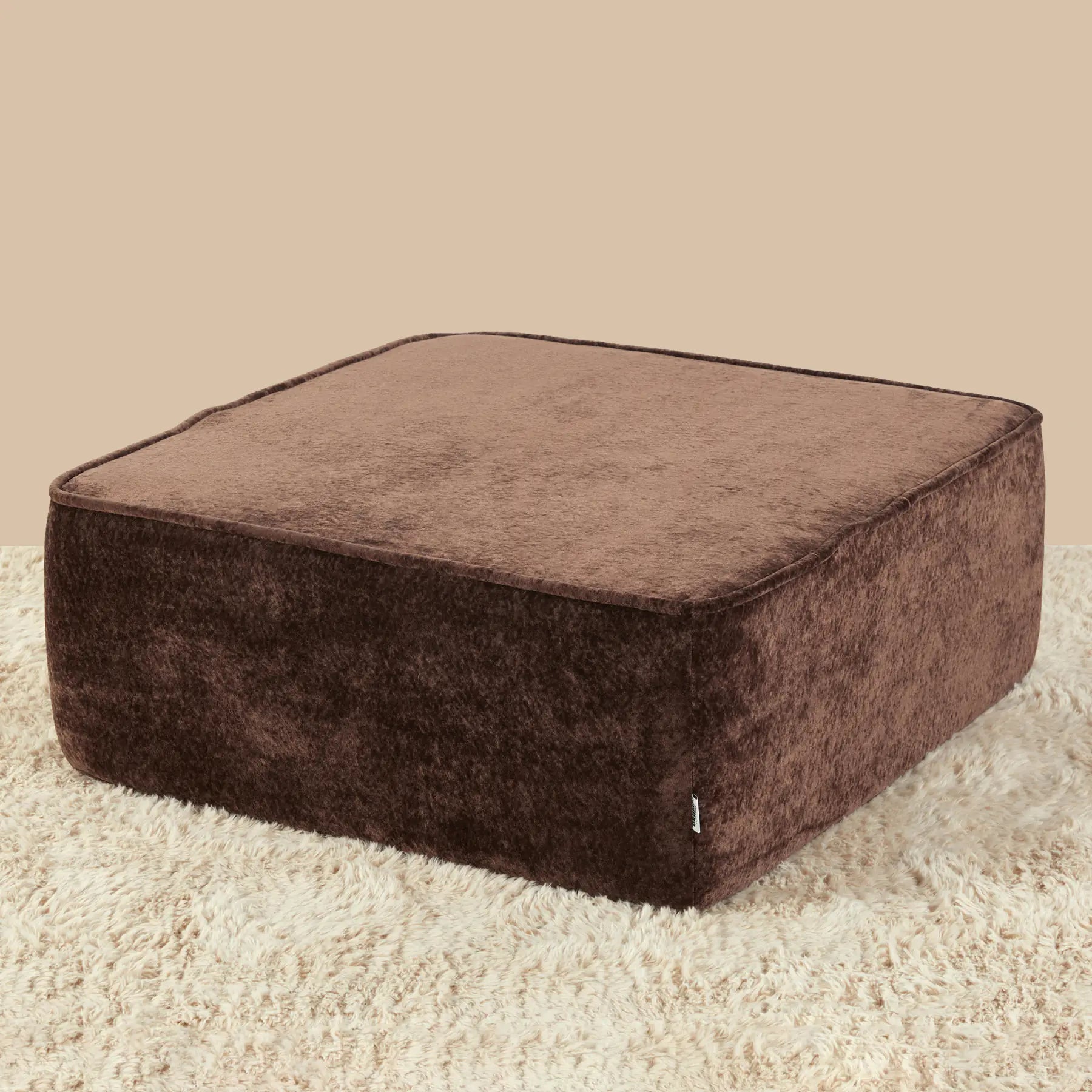 Brown square ottoman on a beige carpet