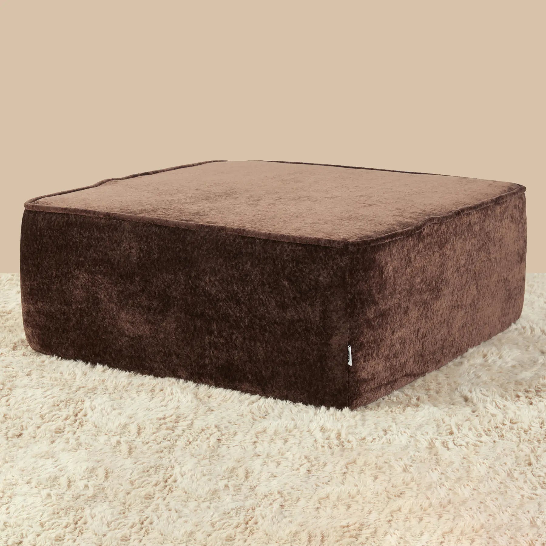 Brown square ottoman on a beige carpet