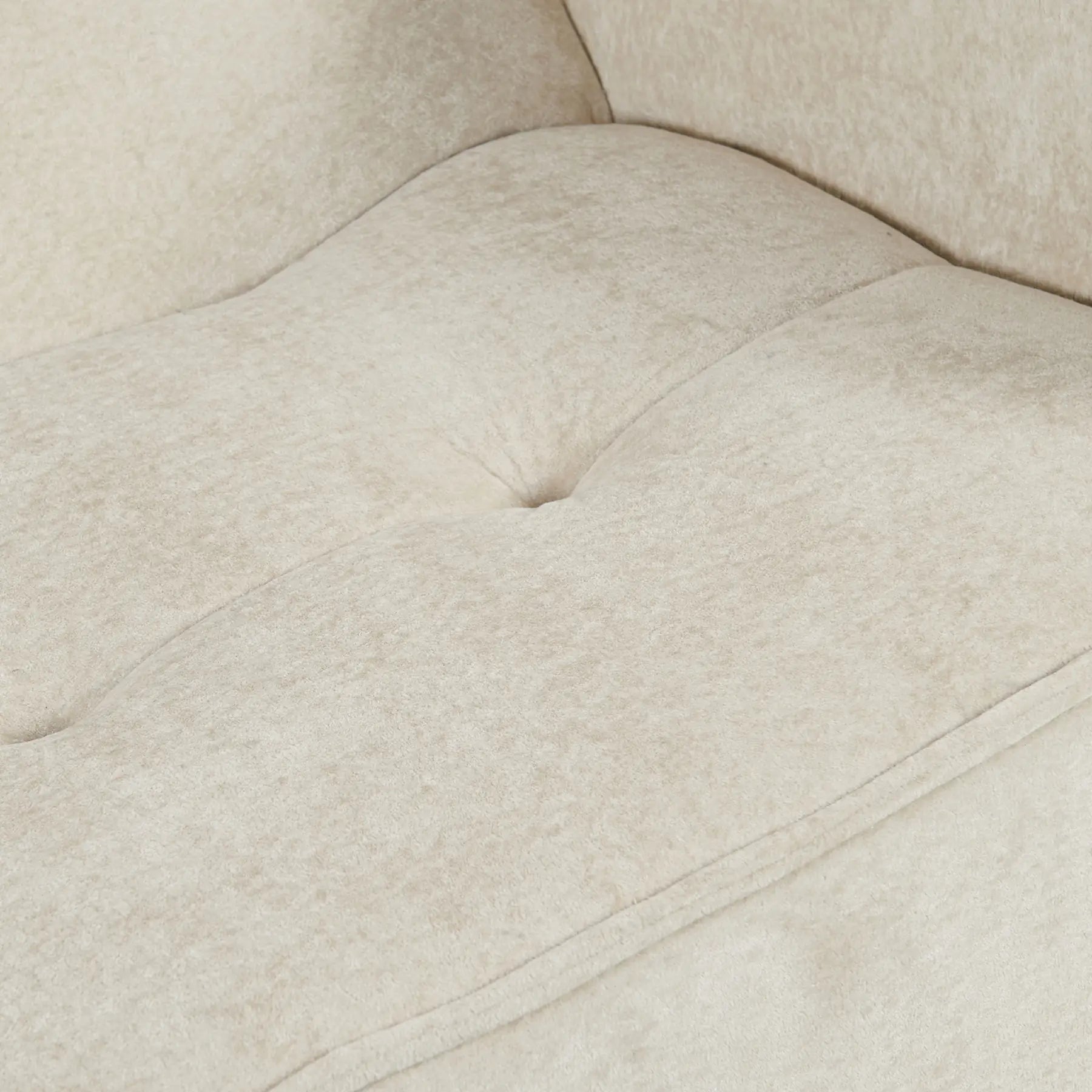 Close-up of a beige upholstered chair with tufted details