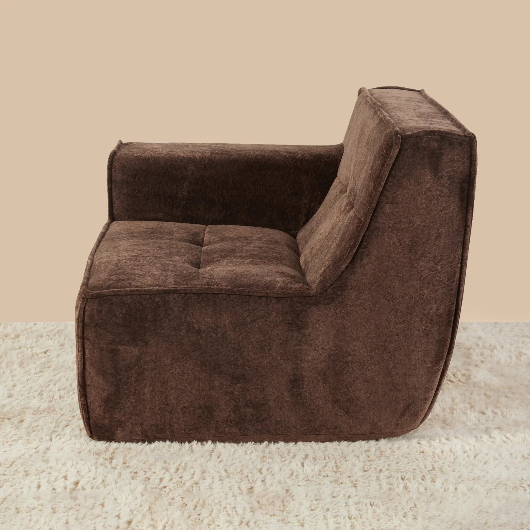 Brown armchair on a beige carpet with a beige wall background