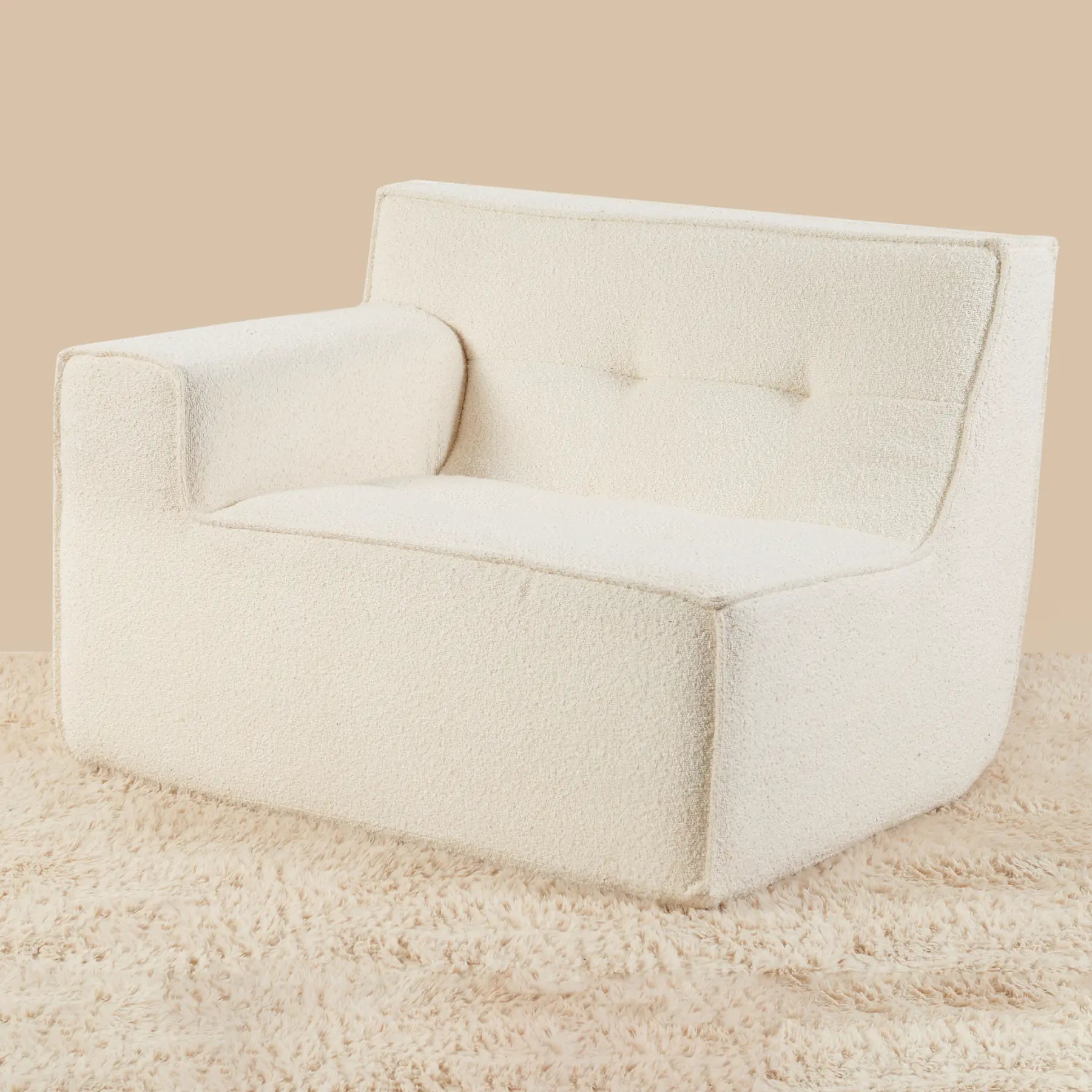 Beige armchair on a beige carpet with a beige wall background