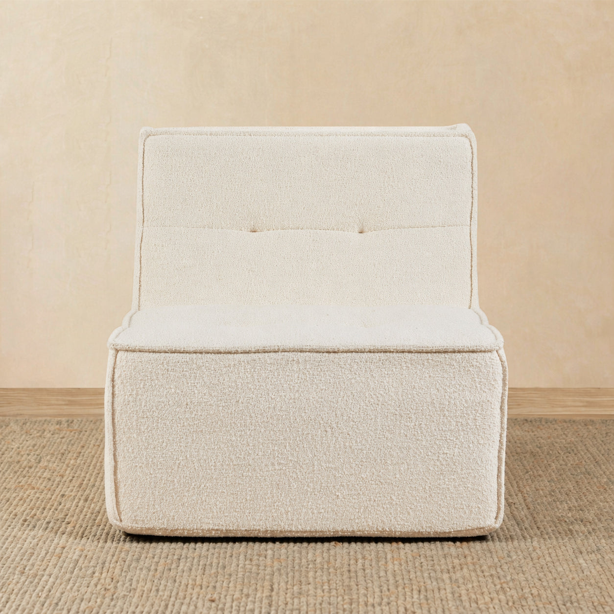 Beige armchair on a beige floor with a neutral wall background