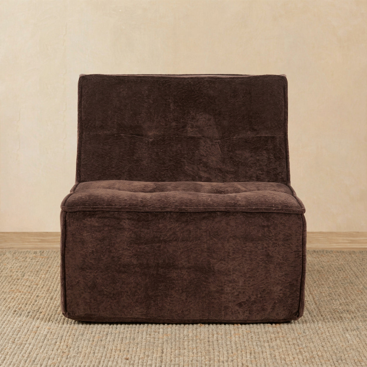 Brown upholstered chair on a beige carpet with a beige wall background