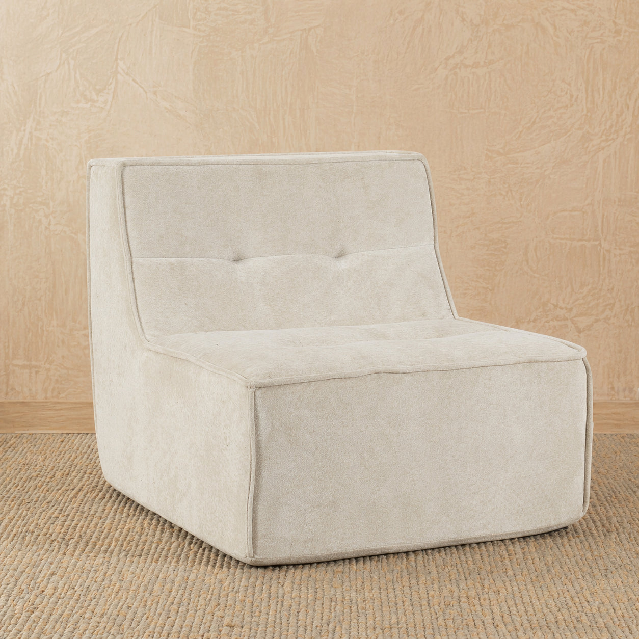 Beige upholstered chair on a beige textured background