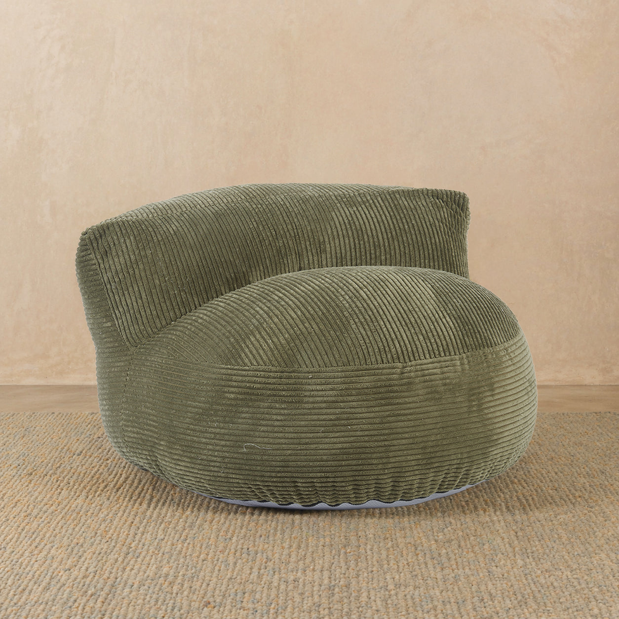 Green corduroy armchair on a beige background