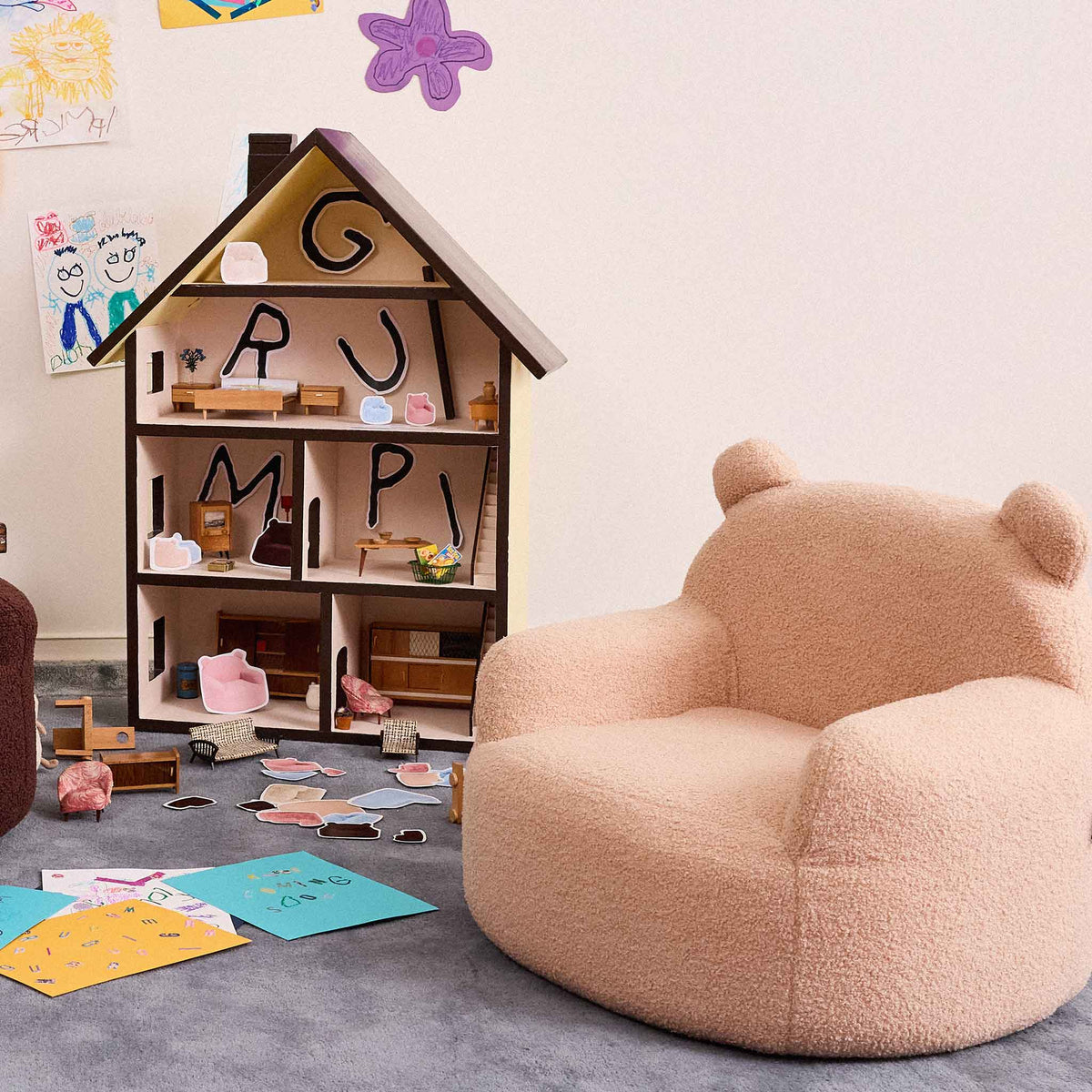 Cream Teddi Kids Armchair beside a wooden dollhouse in a playroom