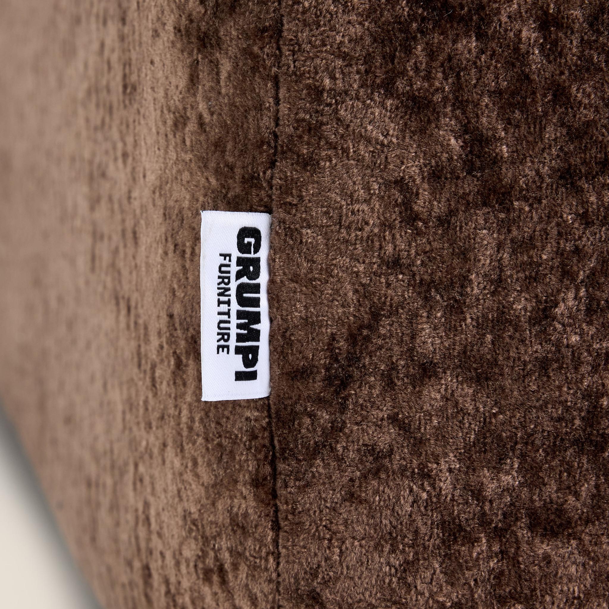 Close-up of a brown textured fabric with a 'Grumpi Furniture' label.

