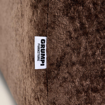 Close-up of a brown textured fabric with a 'Grumpi Furniture' label.


