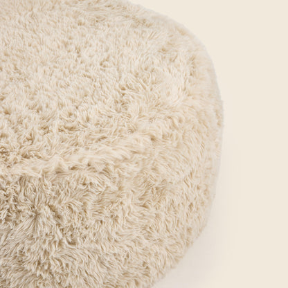 Close up of round beige pouf on a beige background
