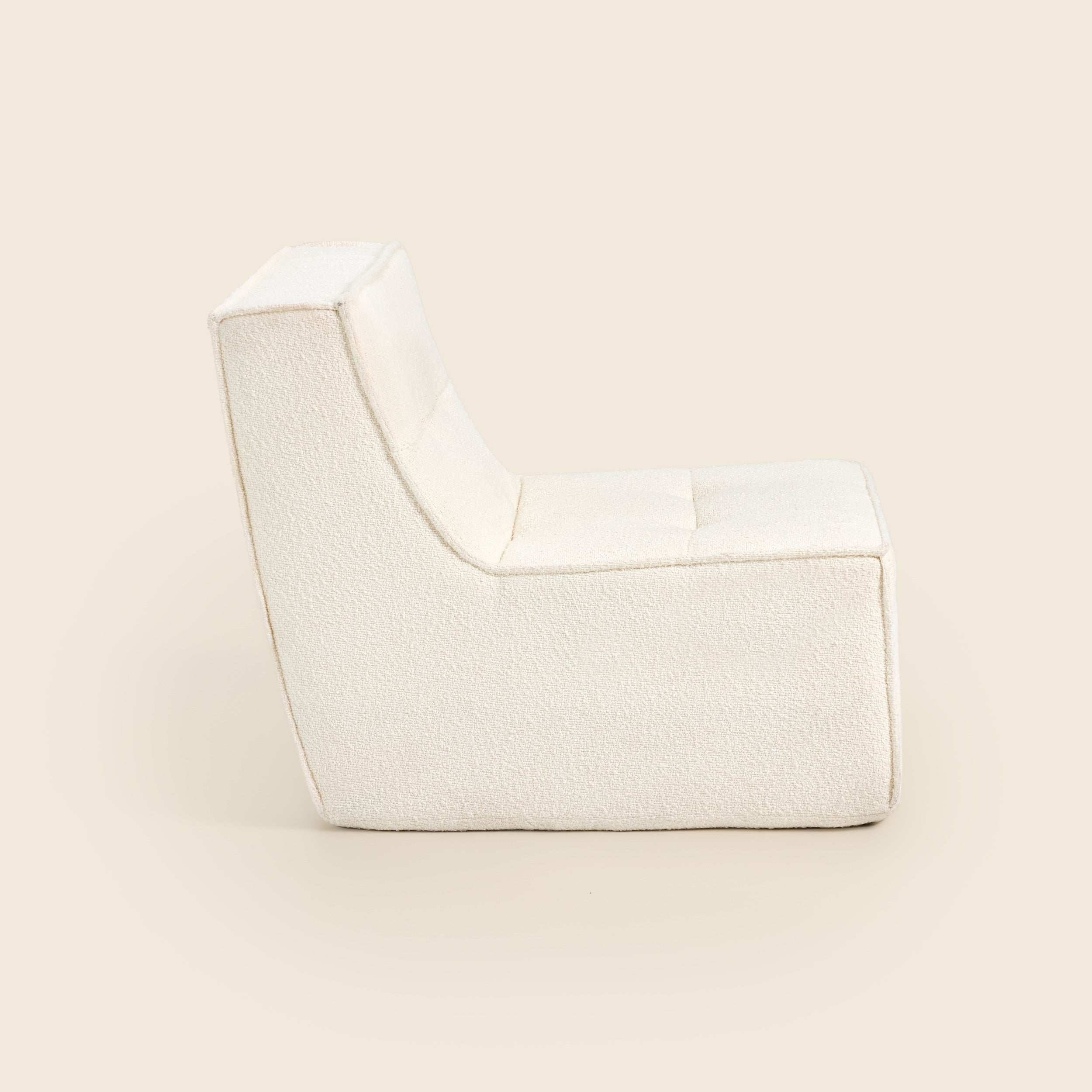 Ivory boucle Loungi modular chair, side view on a beige background 