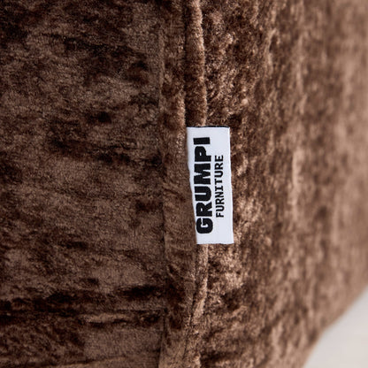Close-up of a brown textured fabric with a 'GRUMPI FURNITURE' label.
