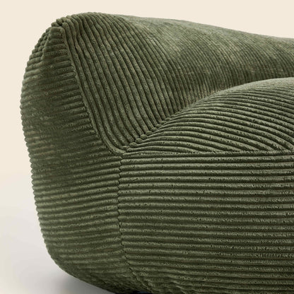Close-up of a green corduroy chair on a light background
