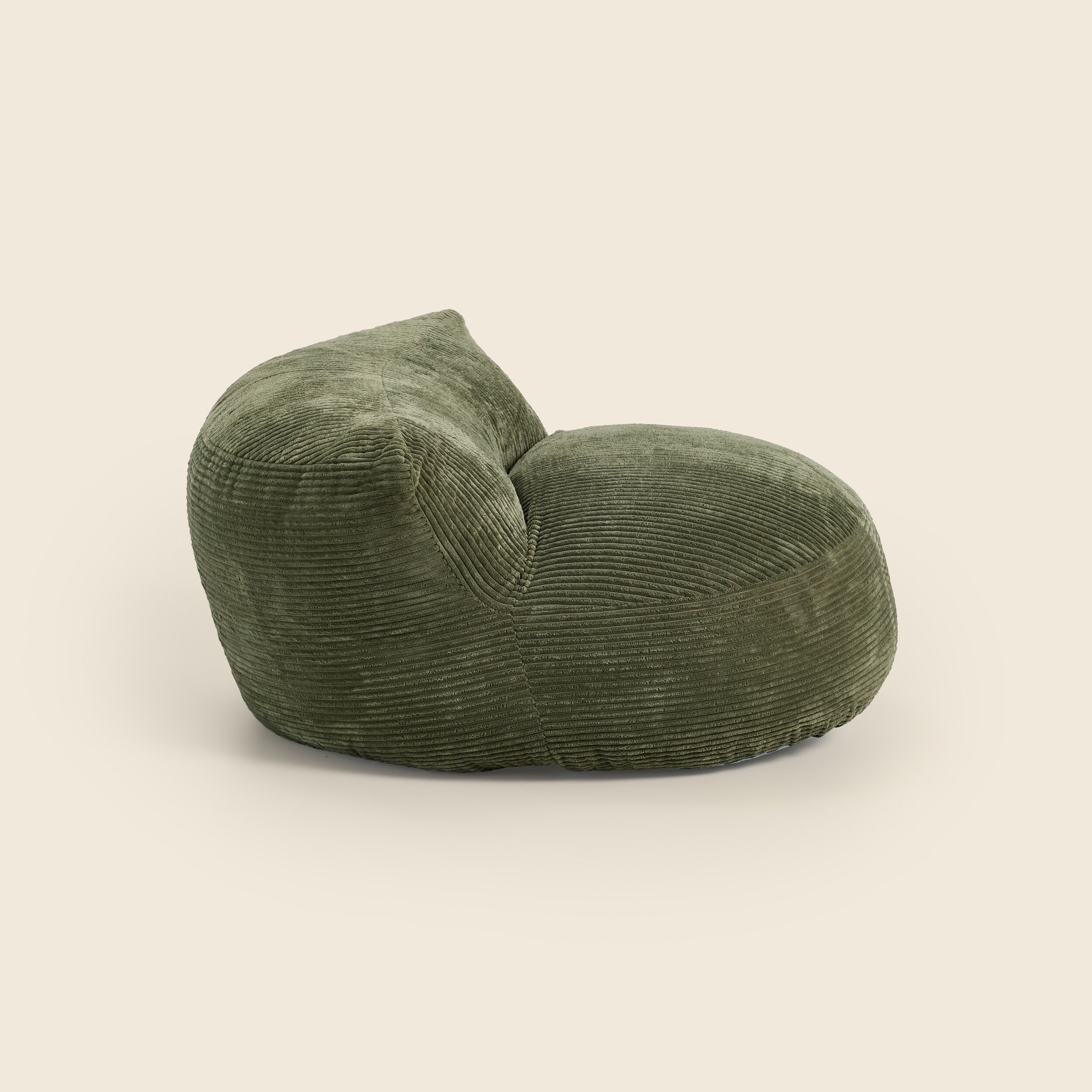Green corduroy armchair on a beige background 