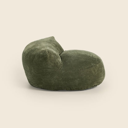 Green corduroy armchair on a beige background 