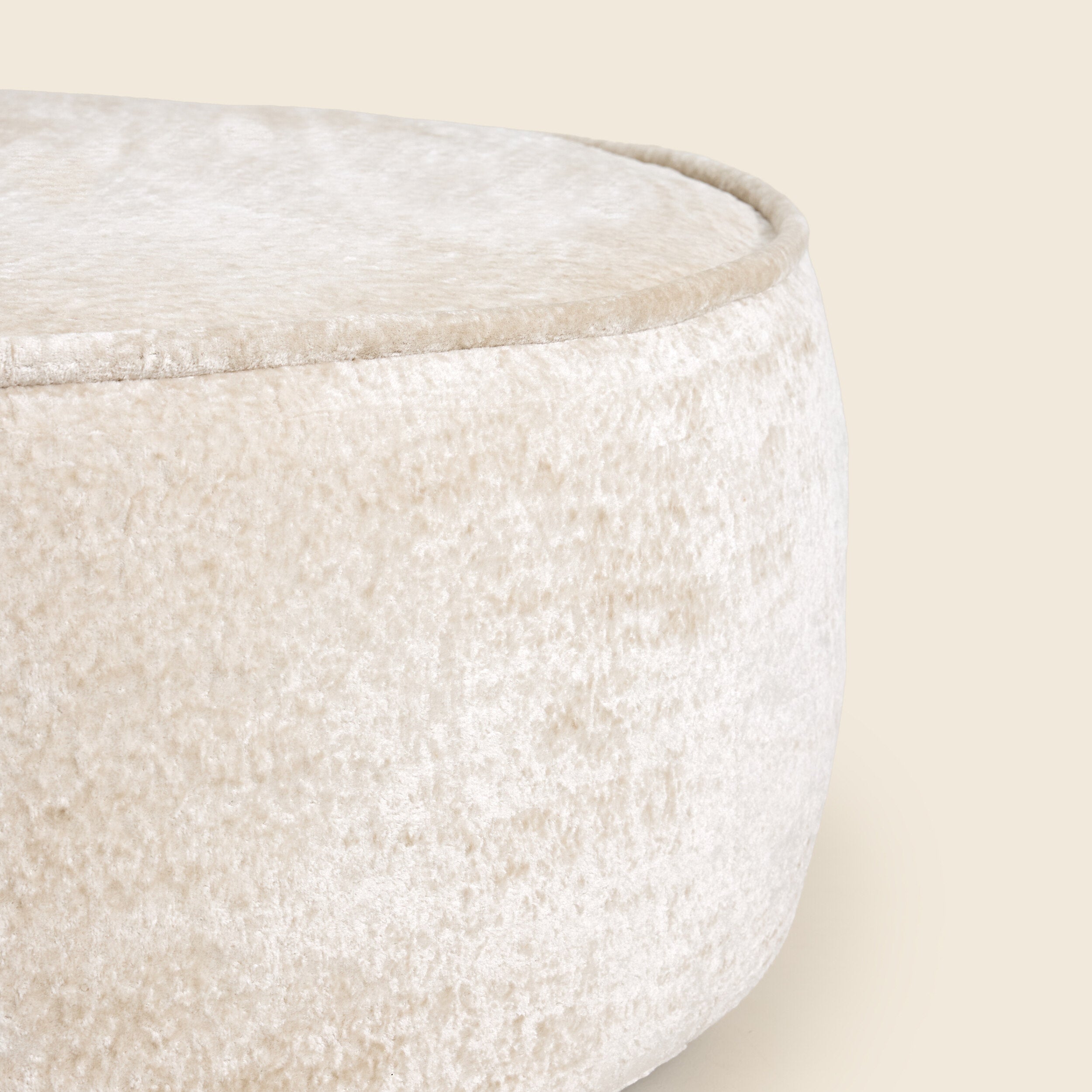 Close up of White textured ottoman on a beige background 