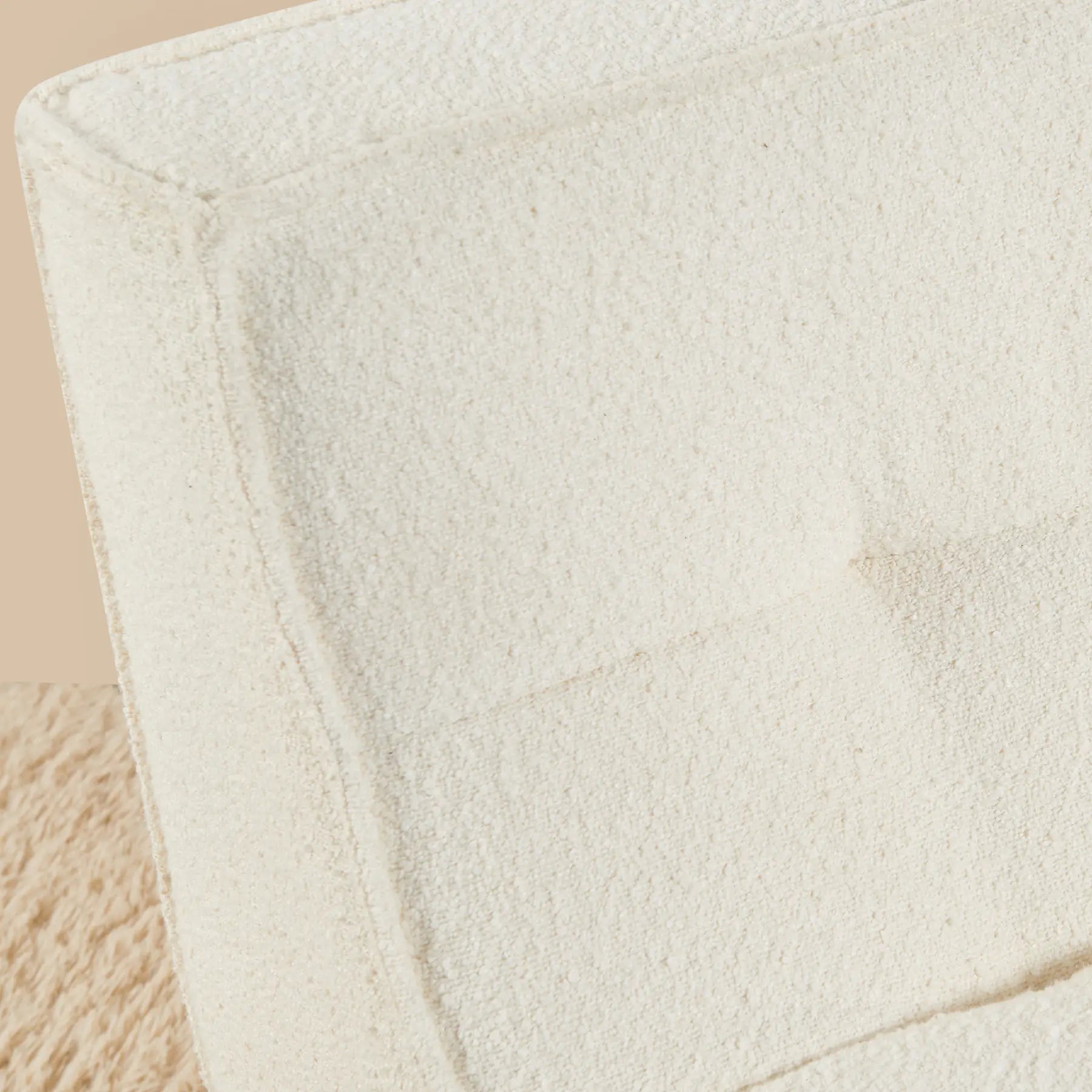 Close-up of a textured beige fabric surface [color: ivory-boucle]