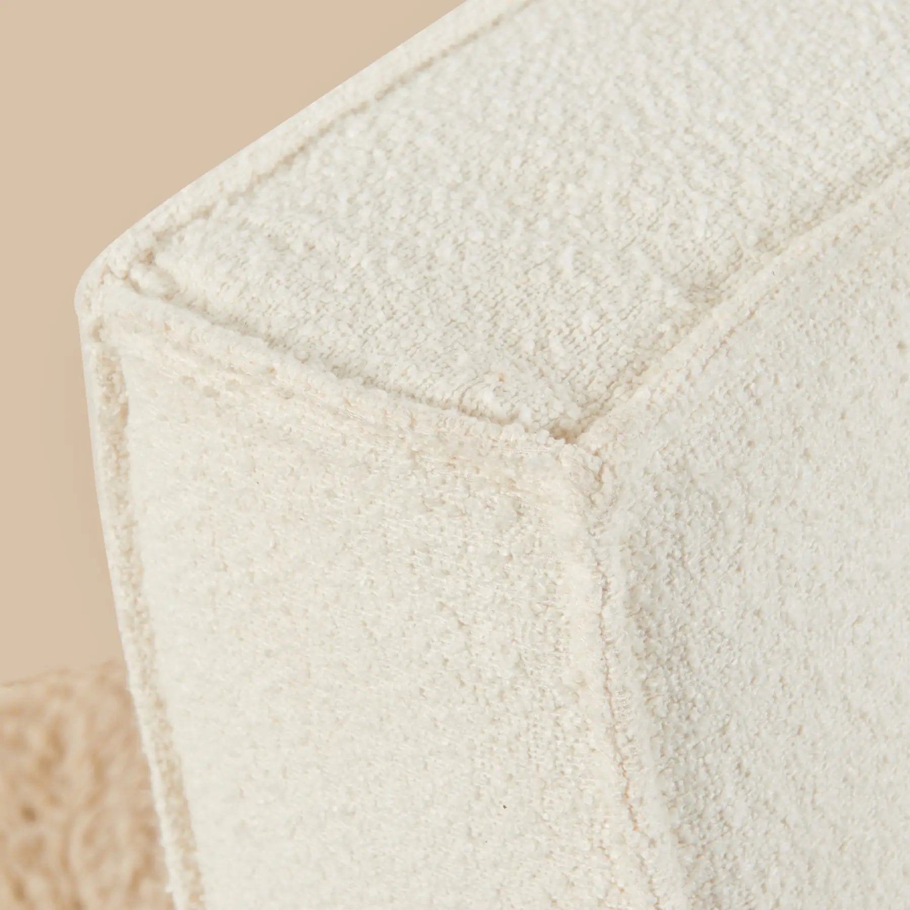 Close-up of a textured white fabric with a beige background [color: ivory-boucle]