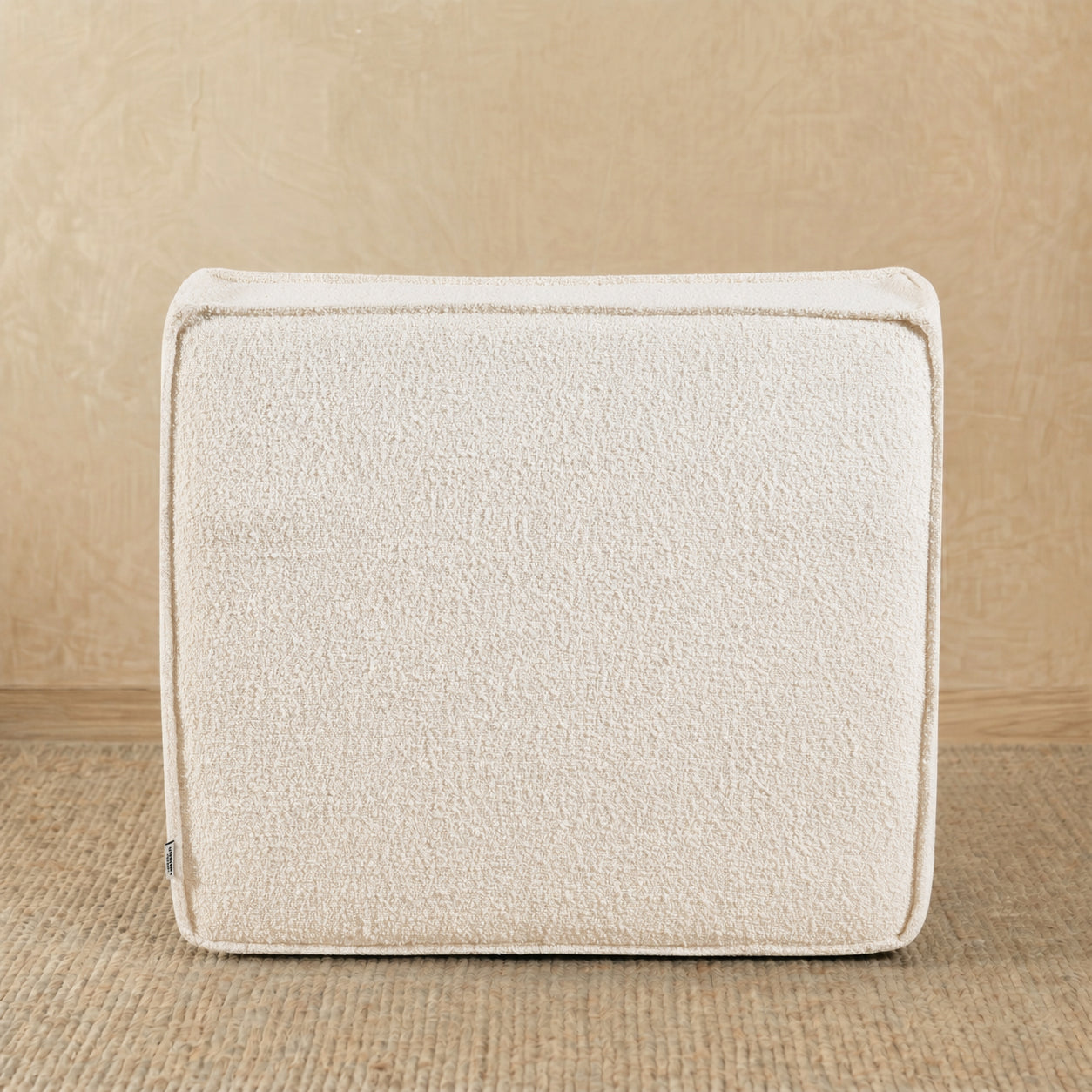 Beige textured cushion on a wooden surface 