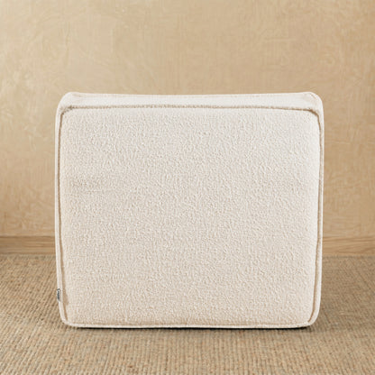 Beige textured cushion on a wooden surface 