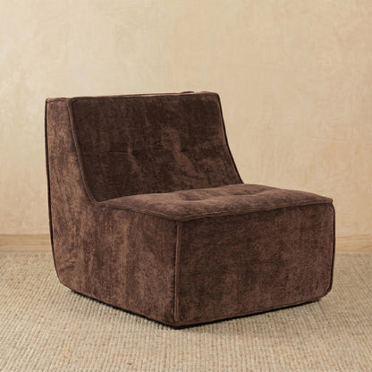 Brown textured armchair on a beige carpet with a beige wall background 