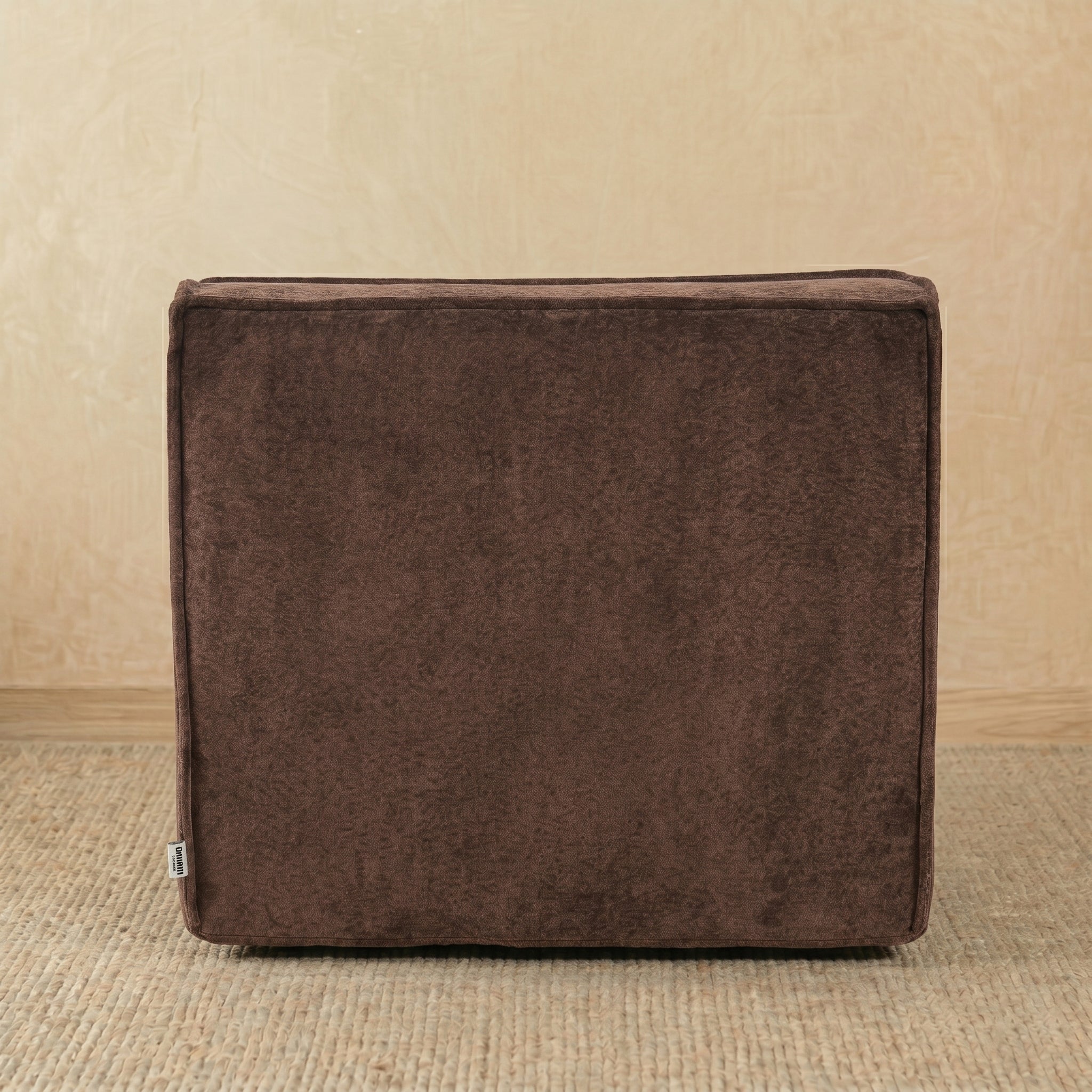 Brown fabric ottoman on a beige background 