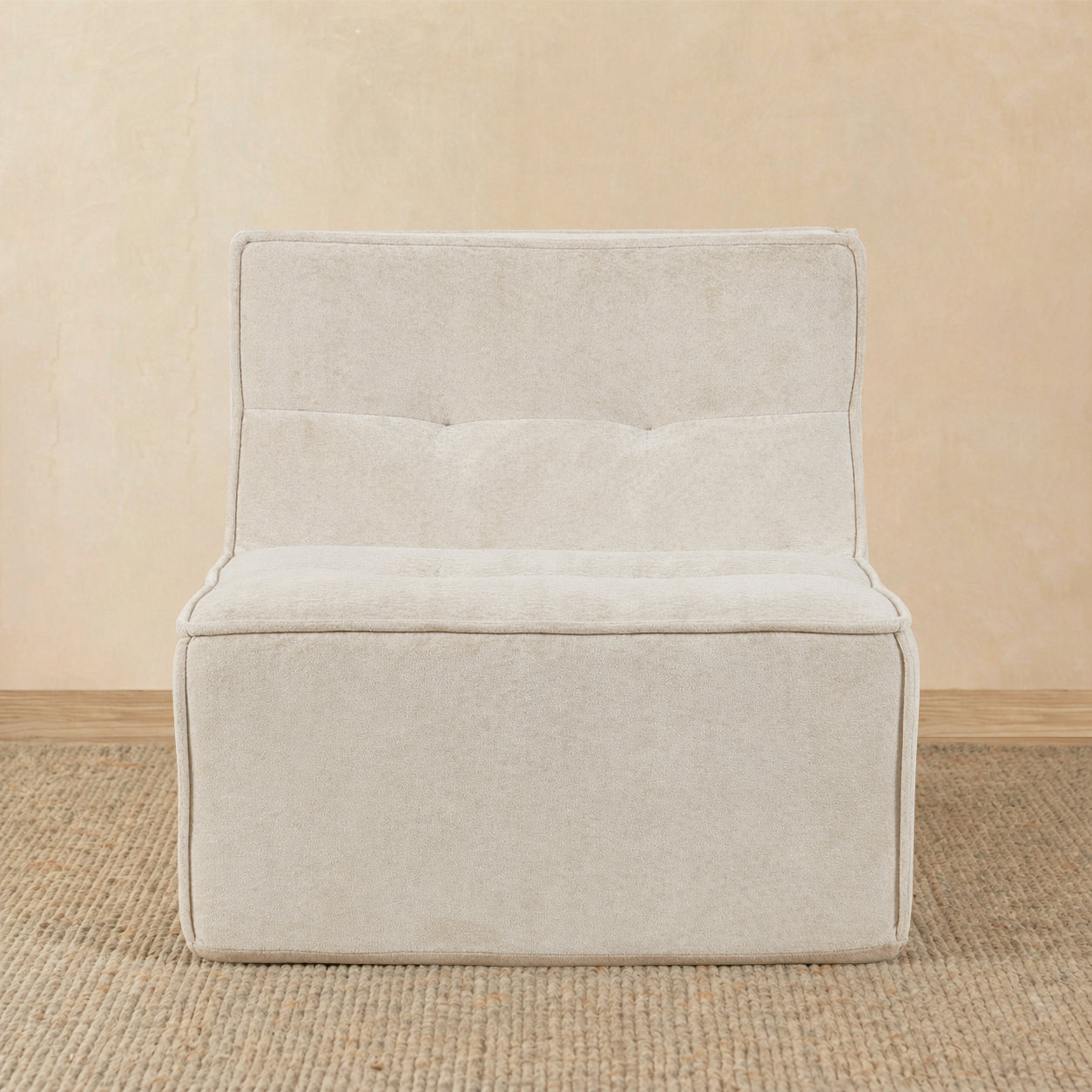 Beige upholstered chair on a beige floor with a beige wall background 