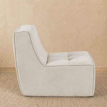 Beige armchair on a beige carpet with a neutral wall background 