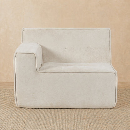 Beige armchair on a beige carpet with a beige wall background 