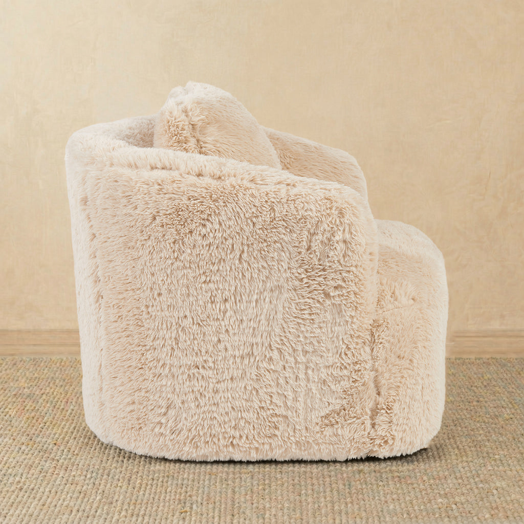 Beige fluffy armchair on a beige carpet with a neutral wall background 