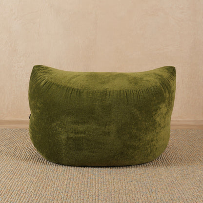 Green bean bag chair on a beige carpet with a beige wall background 