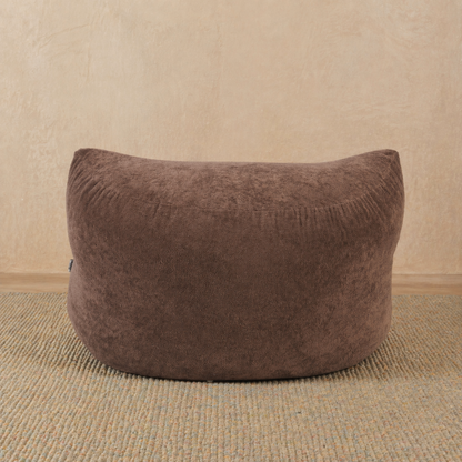 Brown bean bag chair on a beige carpet with a beige wall background 