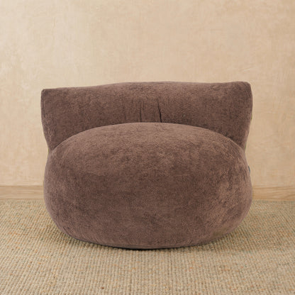 Brown bean bag chair on a beige carpet with a beige wall background 