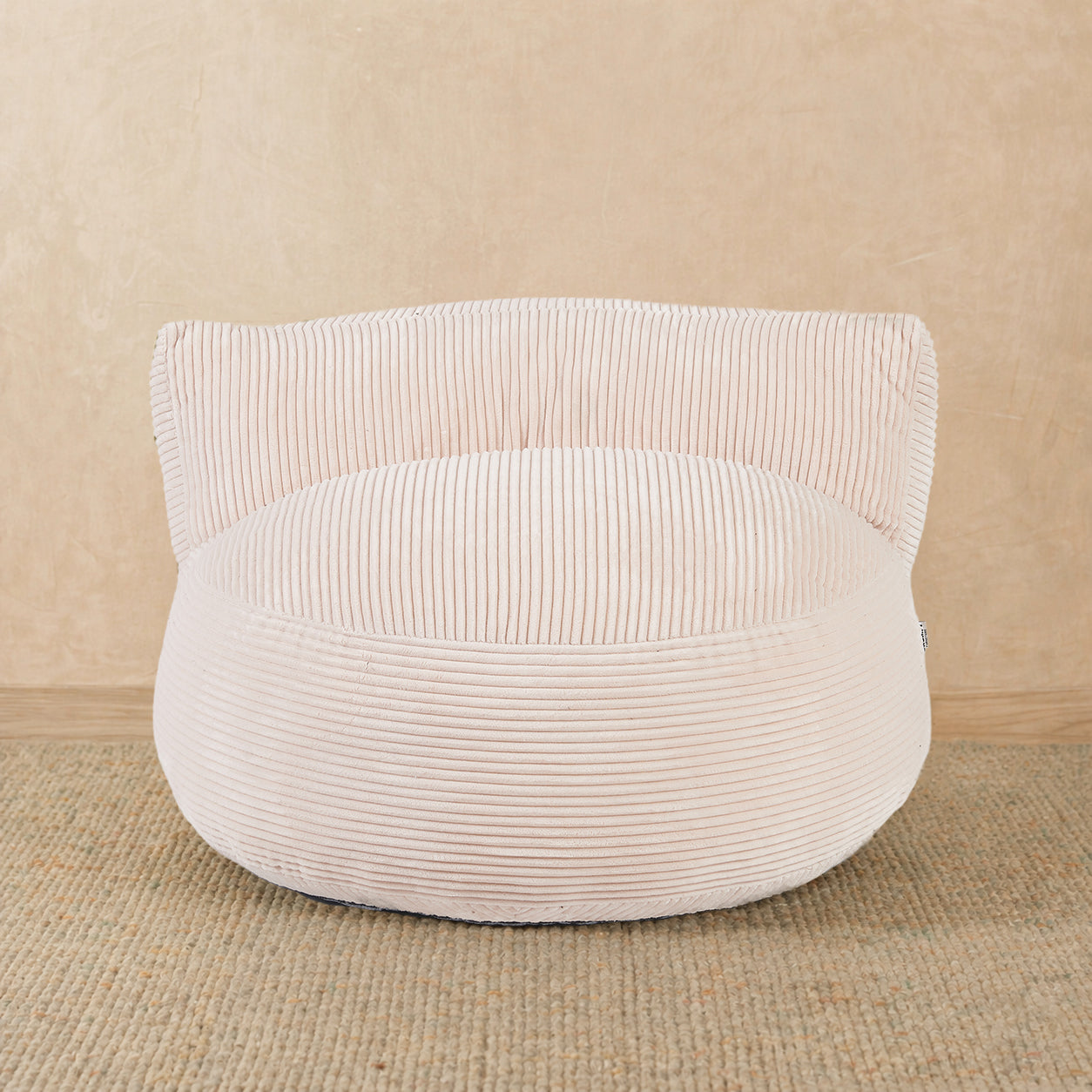 White corduroy ottoman on a beige background 