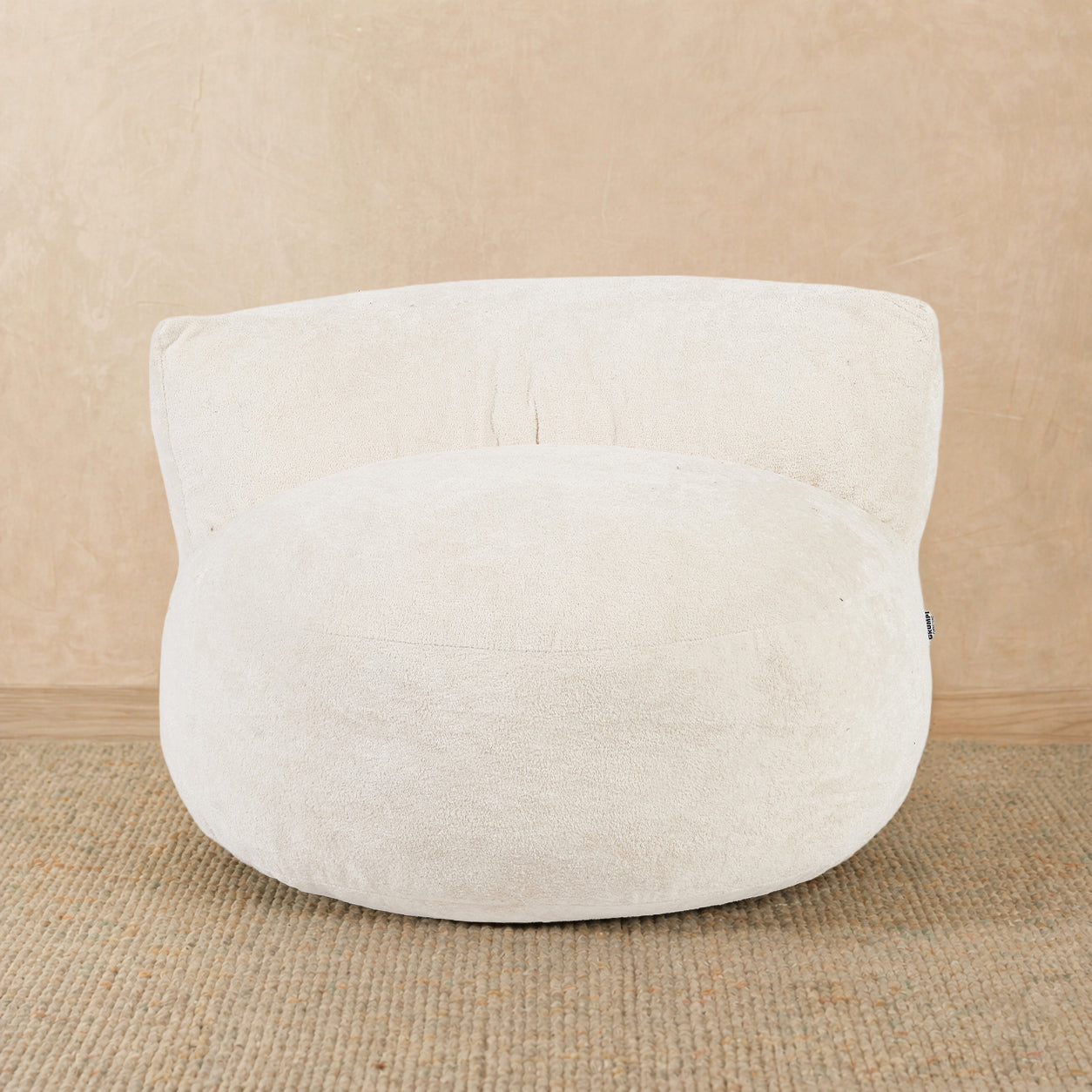 White textured pouf on a beige background 