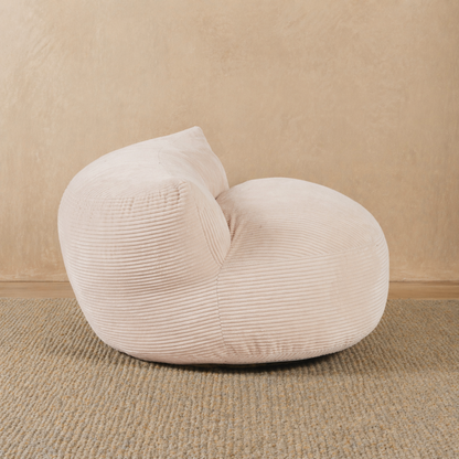 Beige textured bean bag chair on a beige carpet with a beige wall background 
