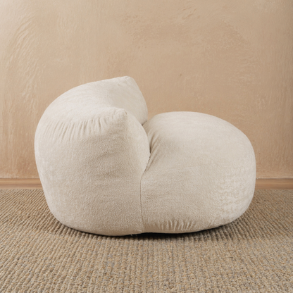 Beige bean bag chair on a beige carpet with a beige wall background 