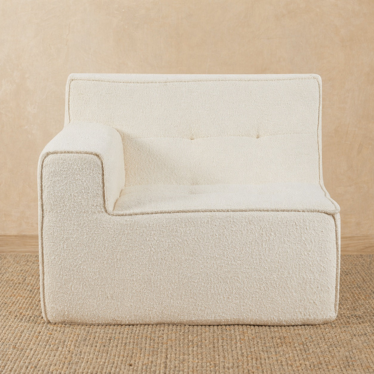 Beige armchair on a beige carpet with a neutral background 