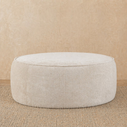 Beige ottoman on a beige carpet with a beige wall background 