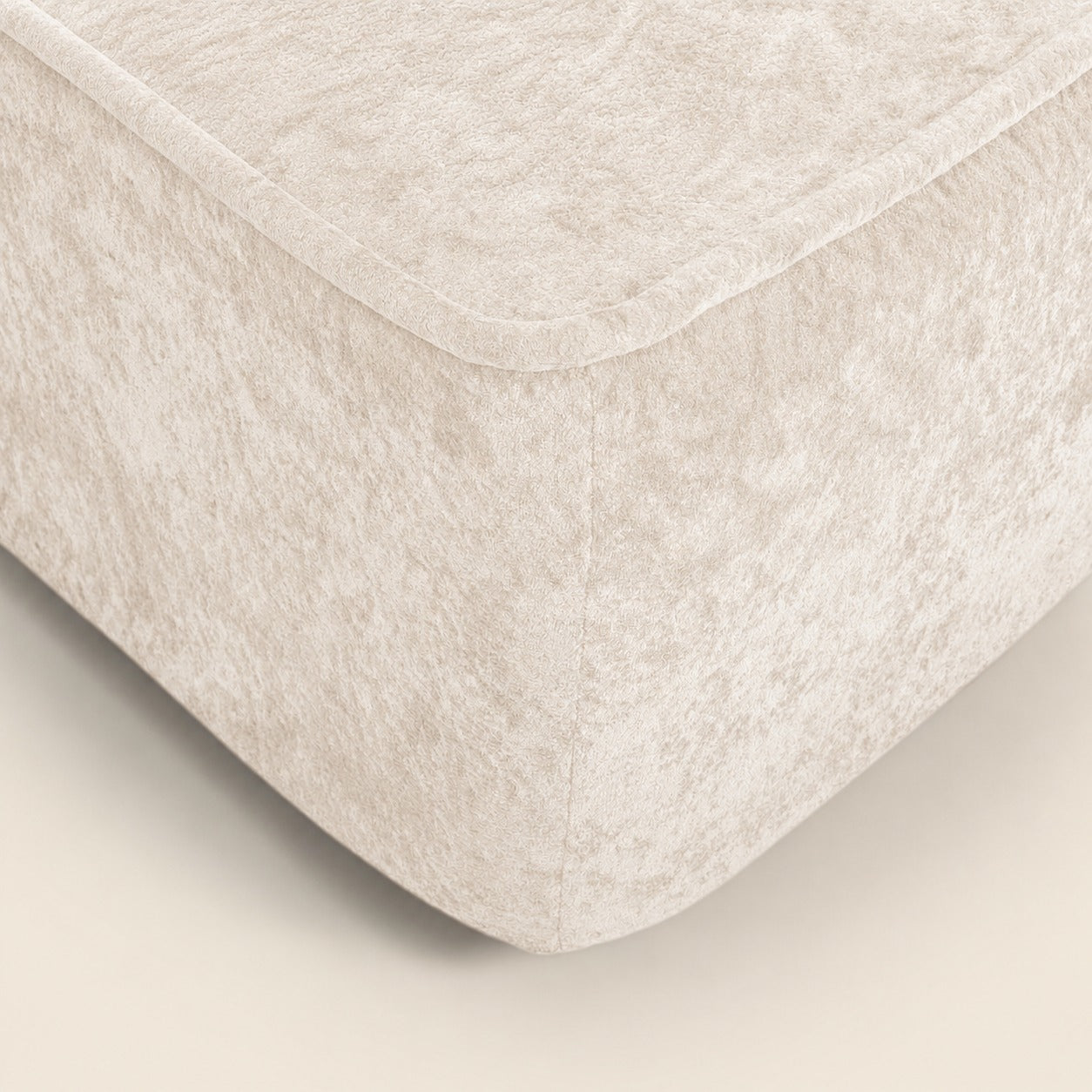 Beige textured ottoman on a beige background
